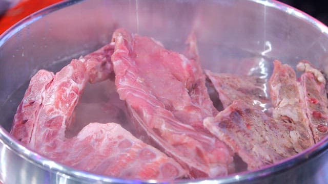 Boiling pork backbones in a large pot