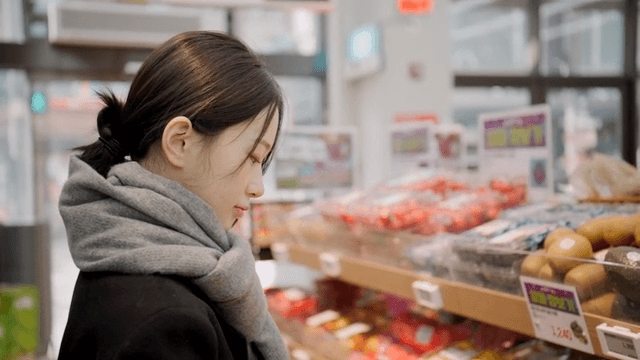 Young woman choosing fruit at grocery store