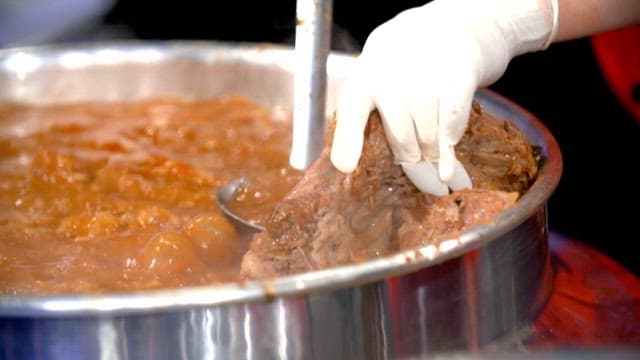 Scene of meat being taken out of pork backbone stew