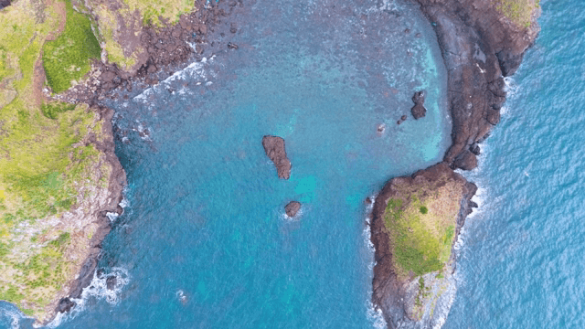 Aerial view of a rocky coastline and clear sea