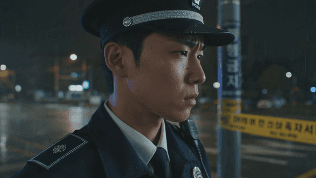 Traffic police officer standing on rainy night