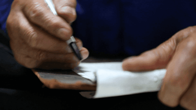 실내에서 청구서에 글을 쓰는 노인