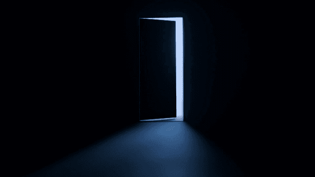 A dimly lit room with an open door