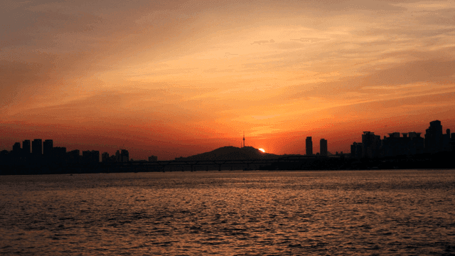 Sunset over a city skyline and river