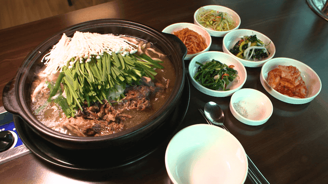 Duck stew and side dishes on table