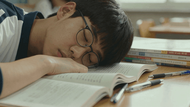 교실에서 교과서에 엎드려 자는 학생