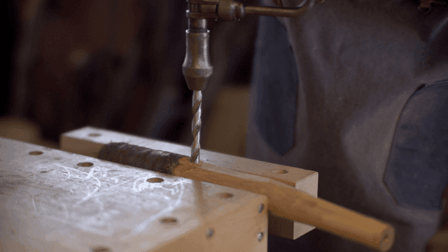 작업장에서 나무 손잡이를 드릴로 가공