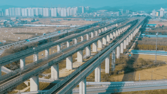 High-speed train on elevated track connecting to city
