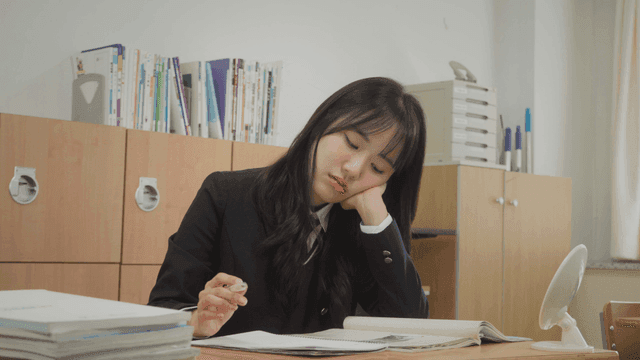 교실에서 공부하며 지루해하는 학생