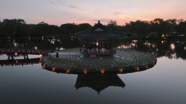 해질녘 고요한 연못 위 전통 정자