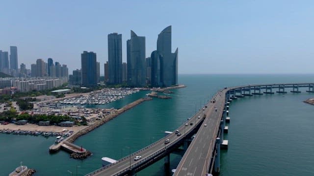 현대적인 고층 건물과 고가도로, 바다가 보이는 부산 풍경