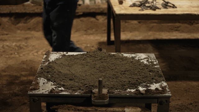 Workers preparing a sand mold in a factory