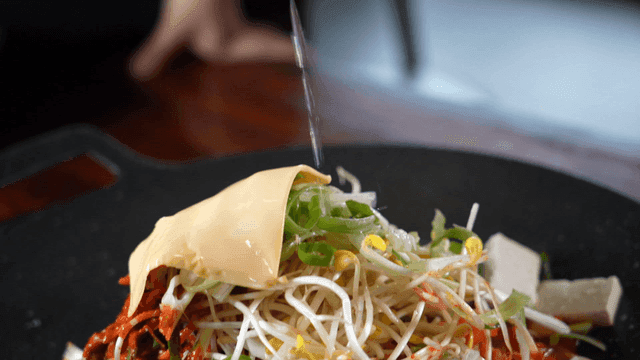 Clear broth poured into budaejjigae