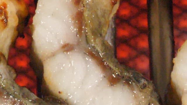 그릴에서 먹음직스럽게 구워지는 장어 조각