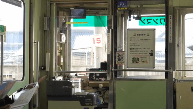Inside a Japanese train with passengers holding maps