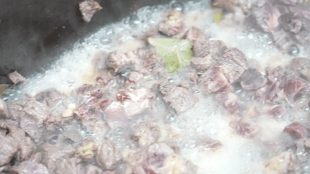 Meat simmering with herbs and bay leaves