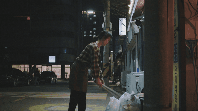 Woman disposing of trash at night