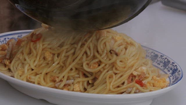 장식된 접시에 담기는 뜨거운 볶음 국수