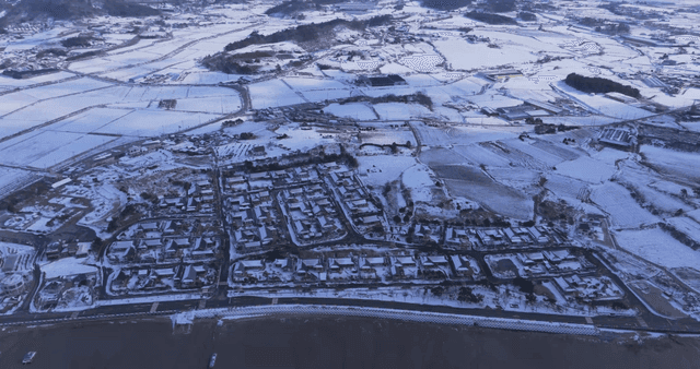 Snow-covered rural hanok village and fields