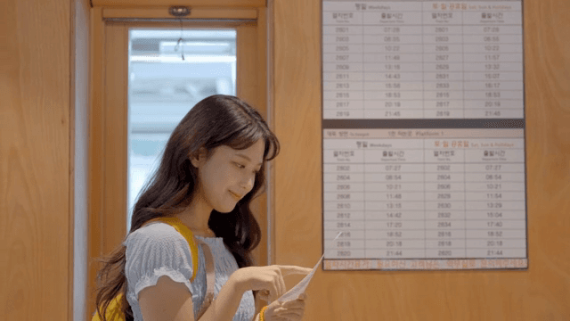 A woman checking the train schedule indoors