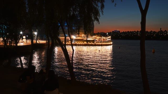 물위에 떠있는 밝게 빛나는 건물과 노을진 도시 스카이라인