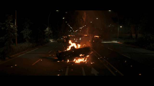 Burning car in middle of road at night