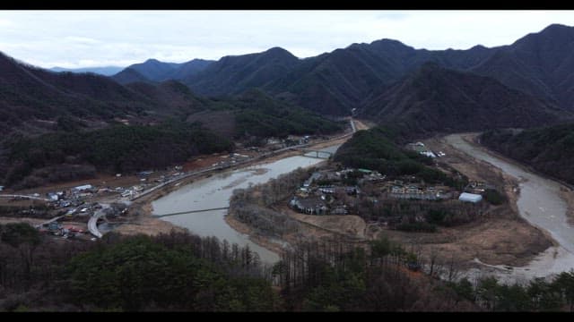 Small town surrounded by mountains and rivers on a cloudy day