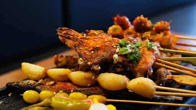 Various types of grilled skewers neatly arranged on an iron plate