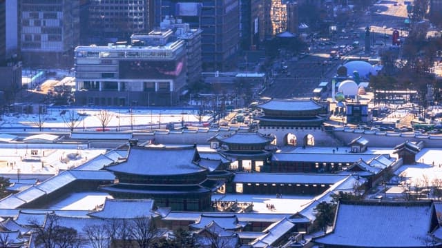 Snow-covered traditional buildings in a busy city