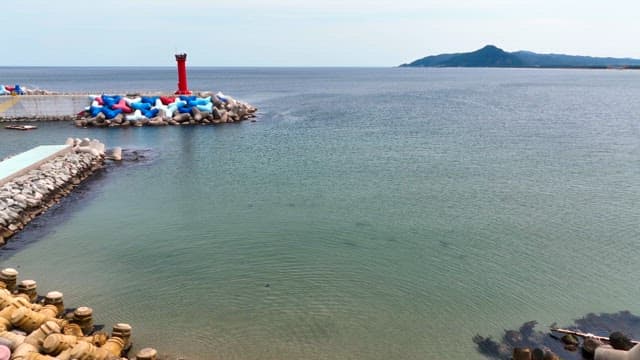 Calm sea with a red lighthouse