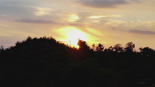 산의 실루엣이 드리운 고요한 석양