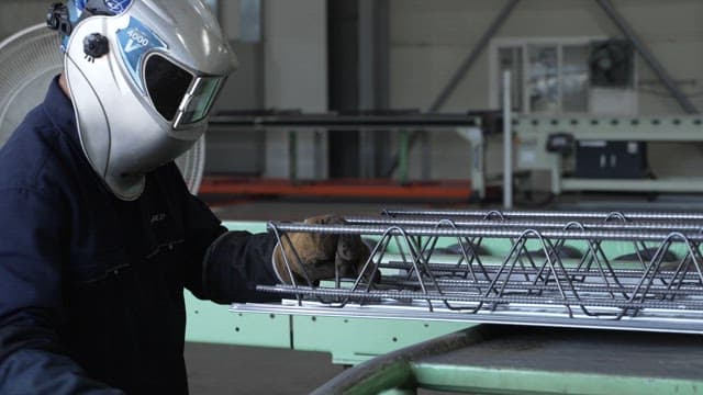 Worker welding metal structures in a factory