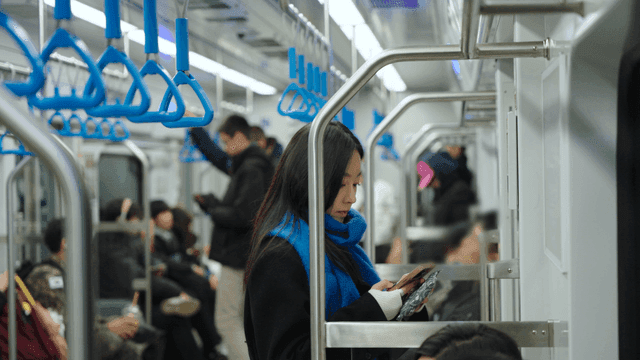 지하철에서 스마트폰을 보는 여성의 옆모습