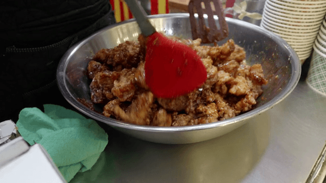 큰 그릇에서 한국식 치킨을 섞는 장면