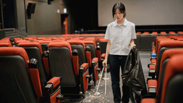 더러운 영화관을 청소하다 한숨을 쉬는 여자