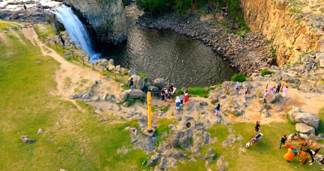 Scenic waterfall with visitors nearby