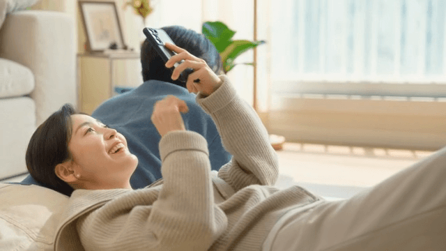 Couple relaxing at home with smartphones