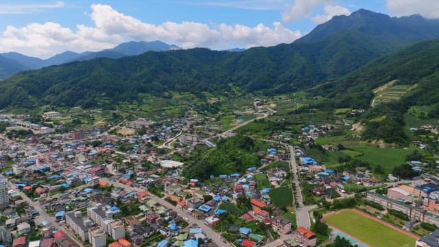 Scenic view of rural town surrounded by mountains