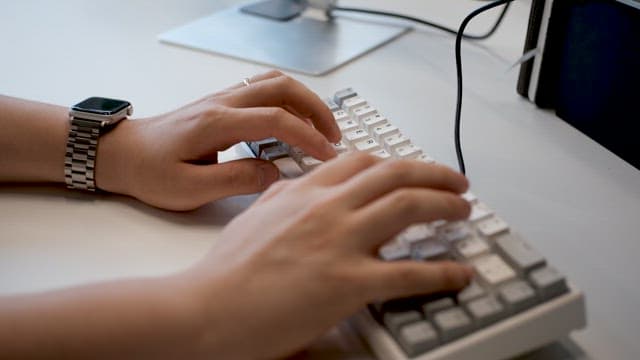 Hands of a Person Typing Quickly on the Keyboard while Working