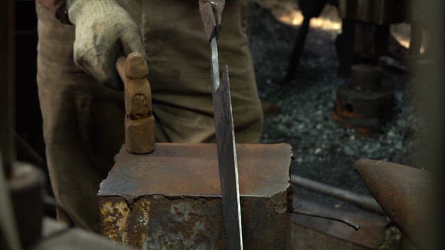 Blacksmith shaping metal with a hammer