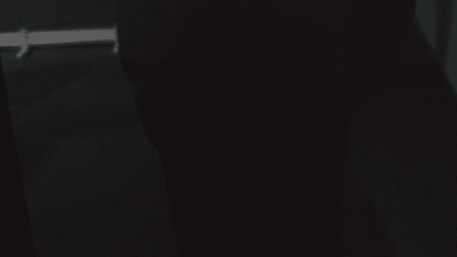 Prison guard escorting prisoner to dark interrogation room