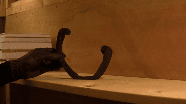 Unique wooden sculpture beside stacked books