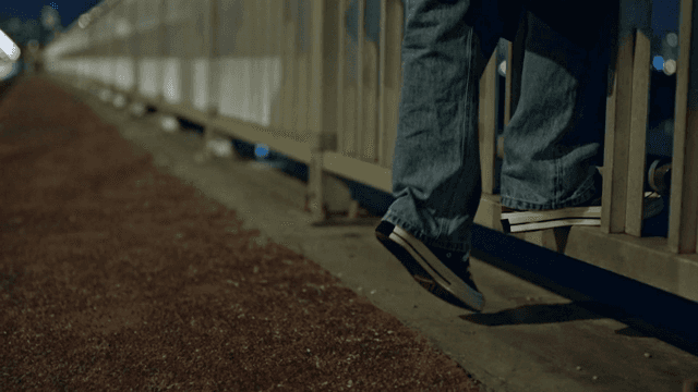Person climbing on a bridge railing