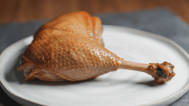 Roasted duck legs on white plate