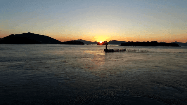 멀리 섬이 보이는 고요한 바다의 일몰