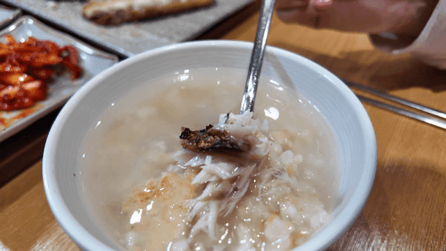Rice water topped with grilled mackerel to be scooped up with spoon