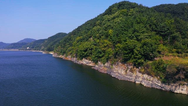 Serene river with lush green mountains on a sunny day