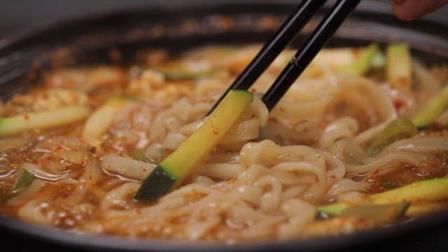 젓가락으로 장칼국수를 들어올리는 장면