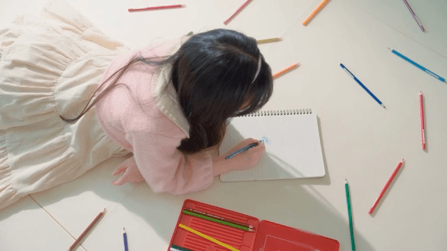Child drawing with colored pencils