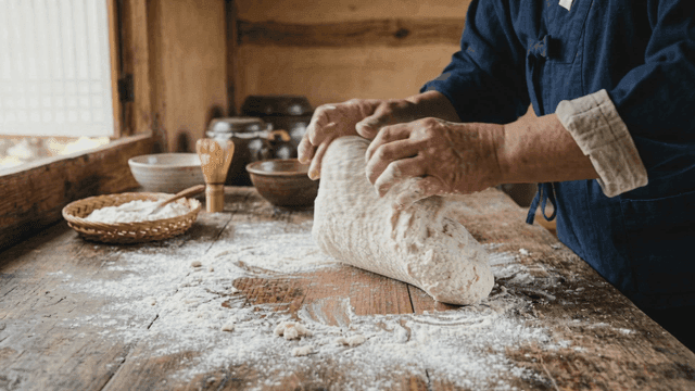 Hands of person in Hanbok making dough in country kitchen